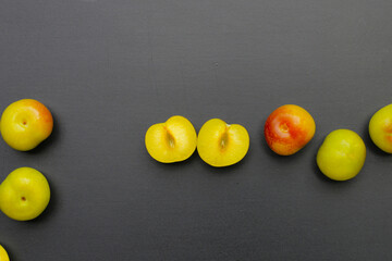 Fresh green plum fruit on dark background.