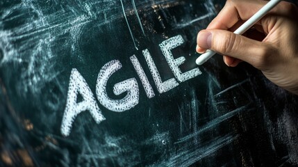 Hand writing agile on chalkboard with bold letters