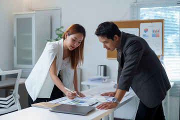 Obraz premium Asian businesspeople analyzing financial charts and graphs in office