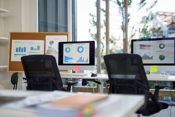 Marketing analysts workplace with computers showing charts and graphs