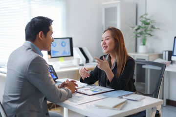 Asian businesspeople discussing about business plan using tablet and computer in office