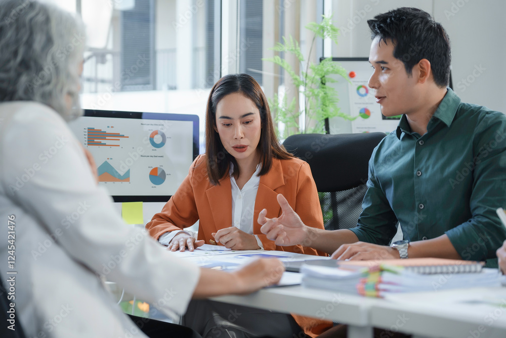 Poster marketing team analyzing statistical charts on computer and documents during a meeting