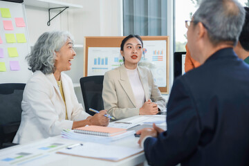 Businesswomen discussing strategy with colleagues during corporate meeting