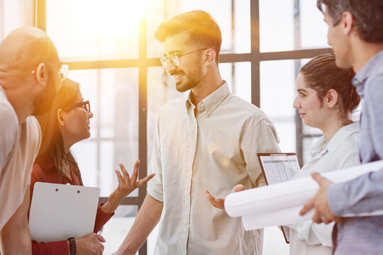 House model on desk over confident team of architects working together in a office.