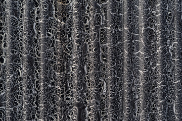 ひび割れた黒色のトタンの壁