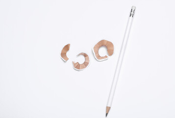White sharpened pencil and shavings on white background