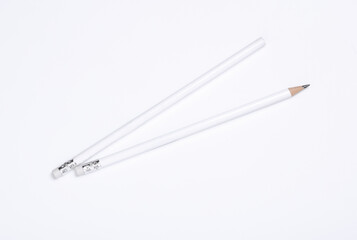 Fototapeta premium White wooden pencils with erasers on white background. Mockup for design
