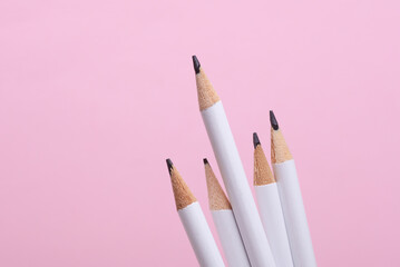Set of white wooden pencils on pink background