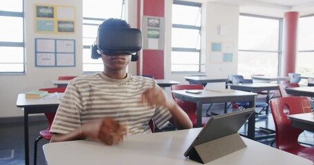 Using VR headset, boy interacting with tablet in school classroom - Powered by Adobe