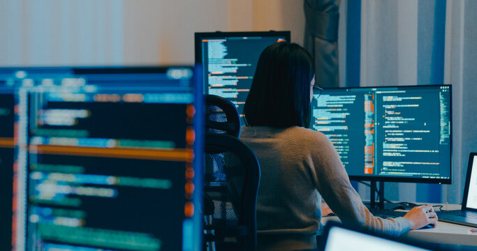 Young Asia female freelance eyeglasses typing write prompt AI bot IT app smart program nomad, video game, terminal with coding language, designer, big data center on desktop computer in night office.