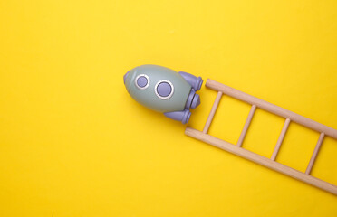 Toy space shuttle and stairs on yellow background. Startup idea