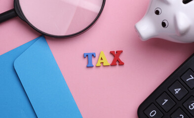 Business sccessories with word tax on pink background. Flat lay