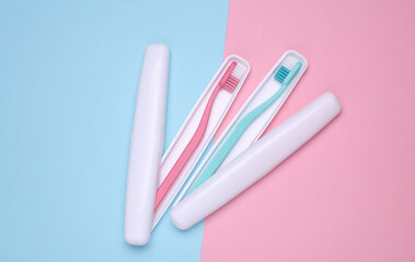Plastic cases with toothbrushes on blue pink background