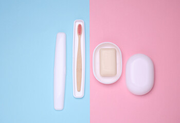 Toothbrush and soap in case and dish on blue pink background