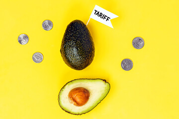 Avocado with tariff flag surrounded by coins on bright yellow background,