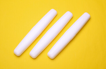 Plastic cases with toothbrushes on yellow background