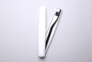 Plastic case with toothbrush on gray background
