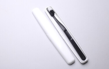 Plastic case with toothbrush on gray background