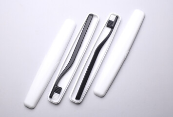 Plastic cases with toothbrushes on gray background