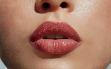 Fototapeta premium Close-up of lips with cherry red brown lipstick or lip gloss 