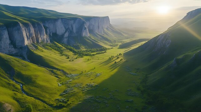 Vast green valley at sunrise, rolling hills with mist, serene landscape showcasing natural beauty and tranquility.