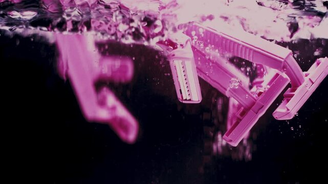 Pink razers splash in water and float.