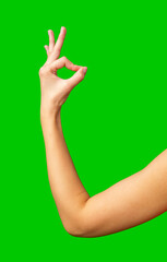 Hand gesture representing approval against a bright green background during a creative project