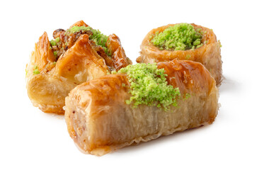 Assorted baklava pieces with nuts and green topping displayed on a white background