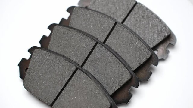 Four brake pads on white background rotate on turntable. Auto parts replacement concept, car maintenance. 