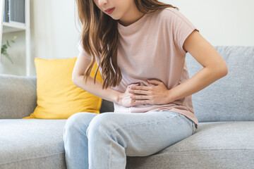Flatulence asian young woman intolerance hand in stomach ache, suffer from food poisoning,...