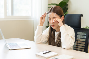 Eye problem concept, fatigue asian young woman tired eyes, irritated rubbing eye dry relief vision pain after work on laptop computer, eye strain, hand holding glasses, suffer migraine, bad blurry.
