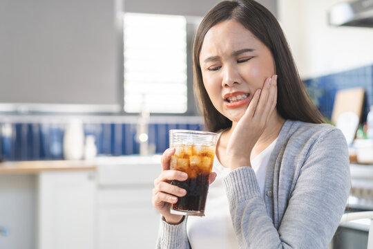 Health care asian young woman touching mouth, expression, girl suffering from toothache, decay or sensitivity cavity molar tooth or inflammation drink cold, sparkling water. Sensitive teeth people.