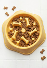 Dry dog food in slow feeder bowl preventing gulping
