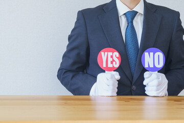 YES・NOのプレートを持つビジネスマン｜ビジネスの質問・疑問　イメージ