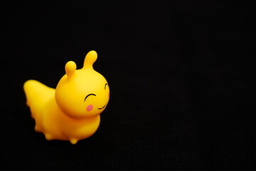 Happy Yellow Rubber Caterpillar on Dark Background