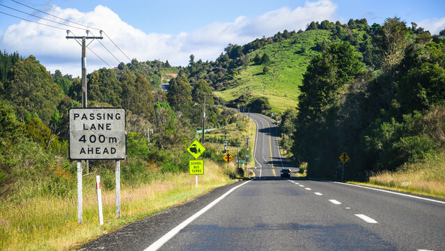 Passing Lane 400m Ahead road sign on a winding road. North Island. New Zealand.