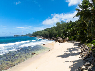 Aerial view of tropical beach and blue sea. Seychelles, Mahe. Anse Takamaka Beach.