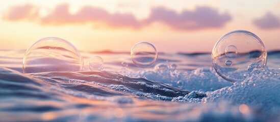 Close up of transparent soap bubbles floating on water surface with soft pastel pink and blue hues in background creating a serene oceanic scene