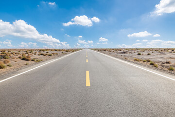 Straight asphalt road stretches through the desert to the distant horizon