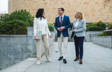 Fototapeta premium Businesspeople walking and talking outdoors in modern city