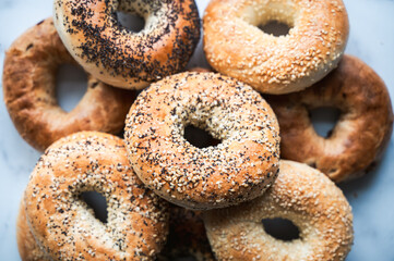 Top view close up of many assorted bagels filling the frame.
