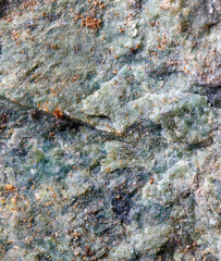 A rock with a greenish color and some brown spots