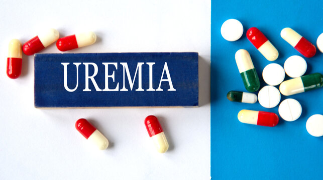 UREMIA - word on a wooden blue block on a background of pills