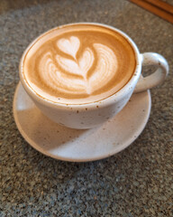 A cup of hot Coffee Latte on a granite pattern table