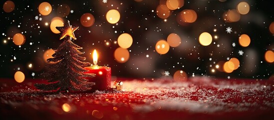 Warm festive red background adorned with golden bokeh lights showcases a candle and miniature Christmas tree with drifting snowflakes throughout the winter season
