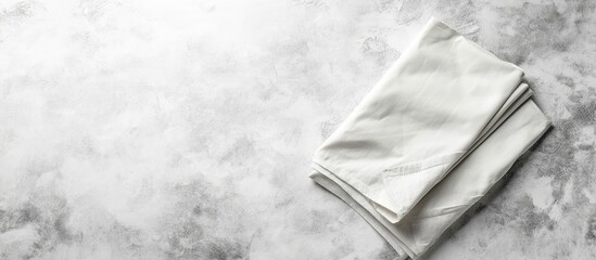 Gray thermal napkins neatly folded on a light gray stone background with ample white space for creative design in the top right corner.