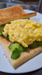 Egg and avocado toast served on a white plate