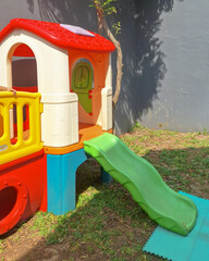 Colorful plastic kids slide toy in backyard playing area