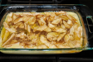 Pear cobbler batter and pears with spices on a baking pan ready for baking.