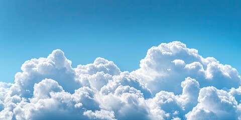 Naklejka premium Cumulus clouds in fluffy white formations against a bright blue sky with ample room for text insertion creating a serene atmospheric background.